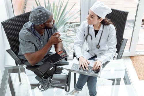 Medical professionals sitting together with a laptop to discuss digital medical marketing.